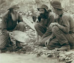 Three men panning for gold, with dog